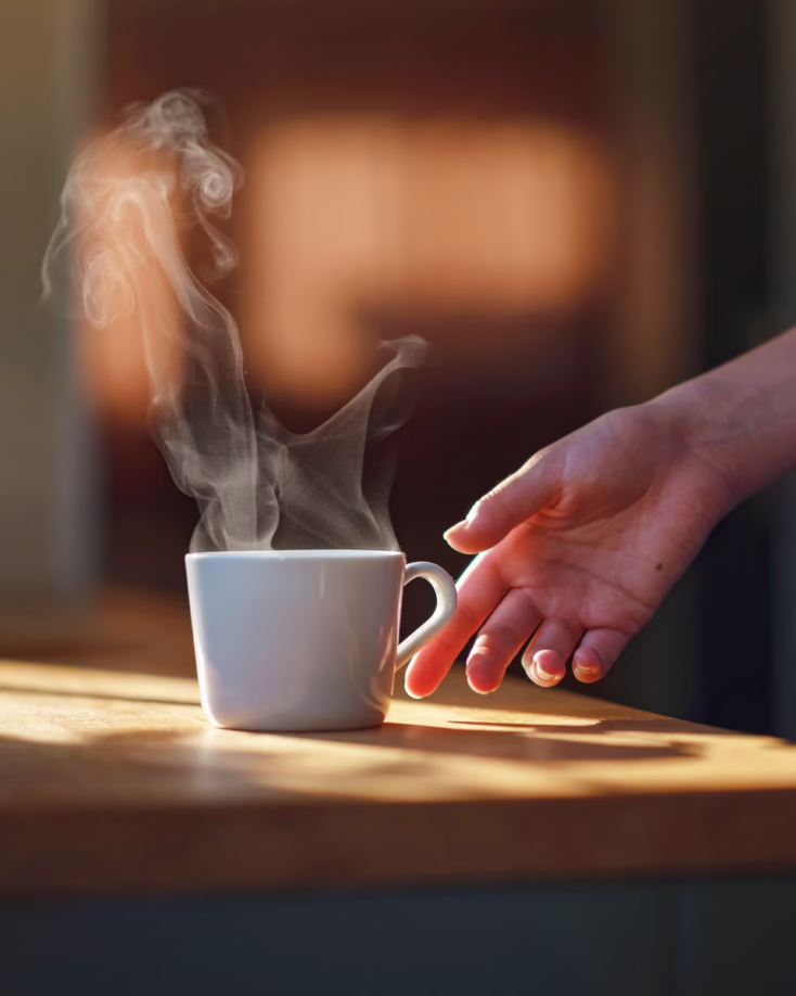 Hand reaching for a cup of coffee